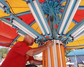 Bob Thompson of Wintersville and an electrician for Bates Bros. Amusement checks a balast on a ride in Kiddie Land