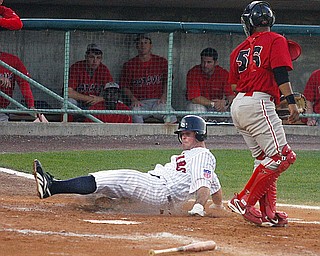 SCRAPPERS - (10) Tim Fedroff slides in to home as (56) Christian Rosa looks on during their game Tuesday night.