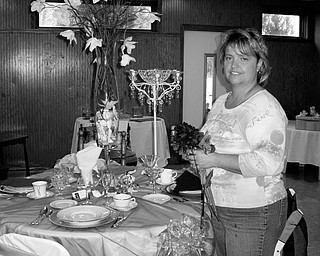 THE BIG DAY: Laurie Dagan, owner of the The Flower Garden Florist and Events by Laurie, works on a wedding reception display in her Warren store. Dagan recently founded the Wedding Network, a local organization for wedding vendors. For more information, go to www.mvweddings.net.