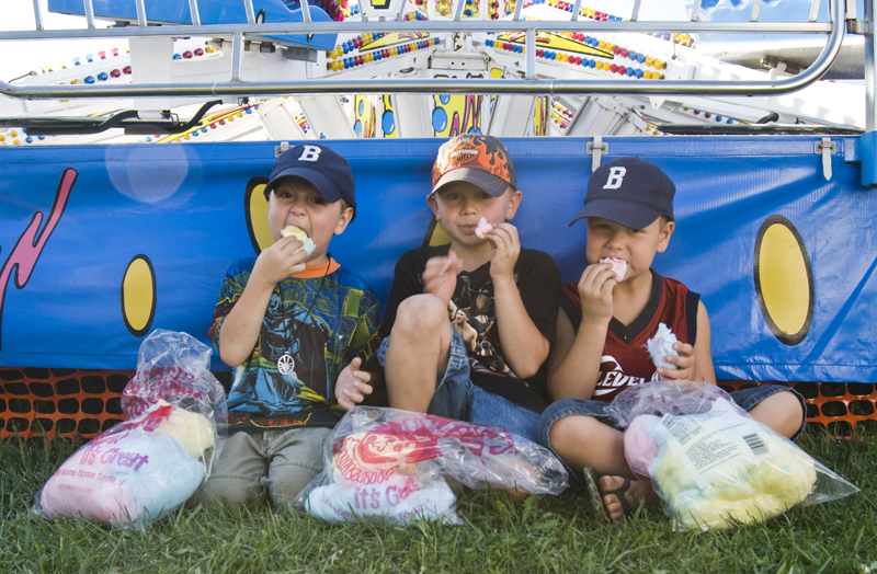 Sweet tooth: L-R Ethan Dunkel, 4, of Boardman; Adam Dewey, 6, of Canfield; and Eric Dunkel, 6, of Boardman, found a shady spot at the Canfield Fair to binge on cotton candy Saturday, August 30, 2008. Daniel C. Britt. 