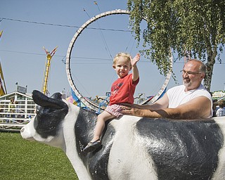 Josh Foley, 2, of Jamestown, NY, steadied by his grandfather, Tim Foley of Canfield, waves from the famous fiberglass cow at the Canfield Fair Saturday, August 30, 2008. Daniel C. Britt.