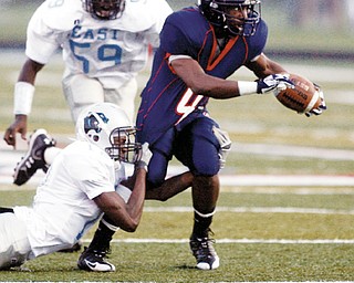 FISTFUL OF 4: Fitch running back Sylvestry Gibbs (4) tries to break free from the grasp of East defenders Michael Thomas (12) as Eric Taylor (59) gives chase during Friday's game at Fitch High Stadium. The Falcons won 49-12.