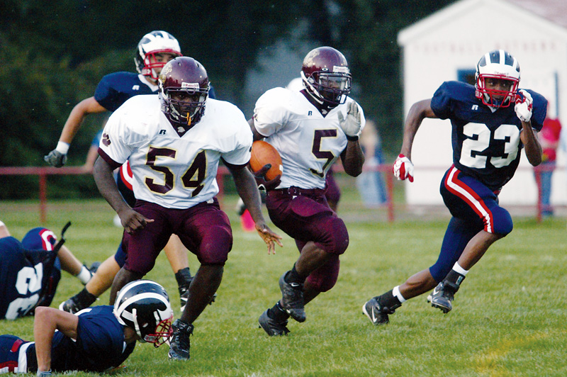 OPEN LANE: Fitzgerald Toussaint of Liberty heads for a first-quarter touchdown during Friday's game against Niles. Blocking is Liberty's Quincy Harris (54), and trying to catch Toussaint is Niles' Anthony Ingram (23).