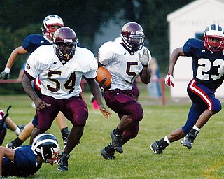 OPEN LANE: Fitzgerald Toussaint of Liberty heads for a first-quarter touchdown during Friday's game against Niles. Blocking is Liberty's Quincy Harris (54), and trying to catch Toussaint is Niles' Anthony Ingram (23).