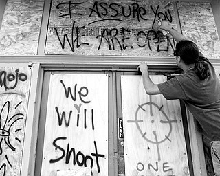 REINFORCEMENTS: Coffee house owner Demian Estevez spray paints the plywood over windows as he makes final preparations for Hurricane Gustav in Marrero, La.