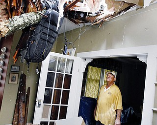 STORM DAMAGE: Richard Bezet looks over damage to the living room of his Baton Rouge, La., home after a tree fell through the roof because of winds from Hurricane Gustav.