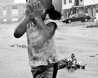 BITING WIND: Taviana Carlson, 3, shields her face from the stinging wind as she makes her way to a neighbor's home after her grandmother's apartment lost electricity when Hurricane Gustav moved through Lafayette, La.
