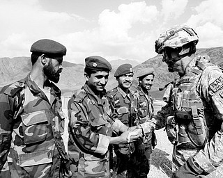 INCREASING OPERATIONS: U.S. Maj. Gen. Jeffrey J. Schloesser, right, shakes hands with Afghan soldiers after arriving at a U.S. base in Nuristan province east of Kabul, Afghanistan. U.S. forces in Afghanistan will increase offensive operations against militants this winter because insurgents are increasingly staying in the country to prepare for spring attacks, the top U.S. commander said.