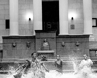 WATER FUN: From left, Juan Rivera, Emanuel Morales, Steven Rivera, Ramon Soldana and Reynaldo Morales, race in the flooded water fountain of the Rutgers University Art Center in Camden, N.J. A flood watch was in effect until this morning because of Tropical Storm Hanna.