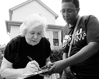 REGISTERING: Linda Graham, right, holds the clipboard as Florence Dziamniski, 82, fills out the voter registration form outside the senior citizen's home in Clairton, Pa. Five days a week, Graham trolls southwest Pennsylvania for unregistered voters, working to add to the big gains Democrats have posted this election cycle. Graham, 45, has taken three months unpaid leave from her job at Pittsburgh's Central Blood Bank to volunteer with Service Employees International Union.