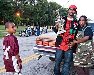 BEST RIDE: Brandon Crosby, 22, of Youngstown, took first place in the car contest at Saturday's Stop The Violence event at Wick Park. Crosby was showing his trophy and his prize-winning 1988 Chevy Caprice, to Stop The Violence organizer Harriett Randolph and young auto enthusiast Ca'Andre Backus, 12, of Youngstown.