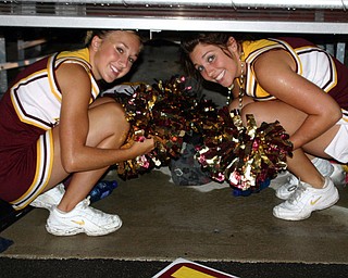 "Jordan Stear and Christina Oddo, South Range cheerleaders, try to
stay dry at halftime of the South Range/Marlington game."