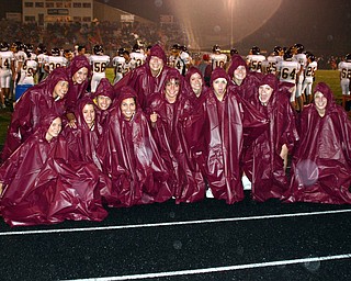 "South Range cheerleaders finally donned the ponchos to try to keep
somewhat dry at Friday night's game.'
