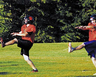 RESUME PLAY: Newton Falls kicker Eric Cooper, left, and quarterback Brian Sole run through drills at hte team's first official practice after a four-day strike suspended the team's workouts. The Tigers were back on the field Wednesday night, just minutes after learning the strike had been settled.