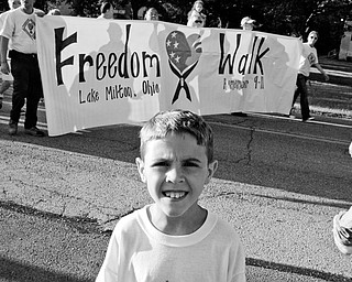 COMMUNITY ORGANIZER: Colton Lockner, 11, of Lake Milton, leads a crowd down the home stretch of the Freedom Walk. Colton organized the walk, which finished at the Lake Milton VFW hall.