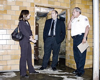 FIREHOUSE OPTIONS: Boardman township trustees Robyn Gallitto, left, and Larry Moliterno, discuss options for repairing the leaky basement of the main fire station on U.S. Route 224 with Fire Chief James Dorman, right.