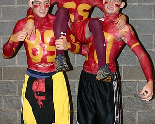 "Wrestlers Jared Miller and Beau Bowden and basketball player Joe
Milan put on their jersys to cheer on the South Range football team."
