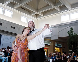 FEELING THE MUSIC: Davine George, left, of Youngstown dances the waltz with dance partner Dean Wellendorf of Canfield. The ballroom dancing exposition took place in the main concourse area of Eastwood Mall on Saturday afternoon. Dance enthusiasts and others who happen to be enjoying a day of shopping at the mall lined the walkway in the course to watch about 73 couples or groups cut a rug.