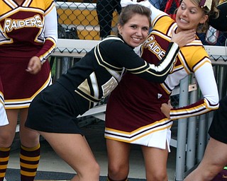"Crestview cheerleader, Darby, and South Range cheerleader, Katie,
pose as friendly rivals before the South Range-Crestview game Friday
night."