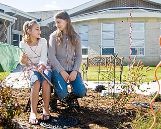 TOGETHER TIME: (Left to right) Bailey Williamson, 9, of Youngstown, and Brooke Smith, 10, of Youngstown, play in the Paul C. Bunn Elementary’s new “Butterfly Courtyard” Sunday afternoon before a ribbon cutting ceremony for the new school.