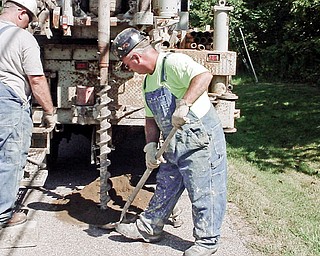 DRILLING DEEP: From left, Dennis Bickford, exploratory drill operator, and Jerry Watts, soils resource specialist, survey and drill on land in Mineral Ridge to look for mines. The Ohio Department of Natural Resources Division of Mineral Resources Management crew drilled on Edwards and Liberty streets.