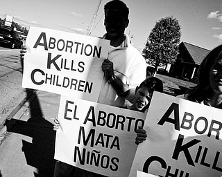 L-R, Michael Lehman of Youngstown, Samuel Sprague, 10, of Bristol and Cindy Lehman show their message in English and Spanish. Daniel C. Britt.