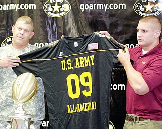 Mooney football player John Simon shows off a jersey presented to him Army Sgt Michael Thompson. Mooney was named to all army team during a ceremony Monday at Mooney.