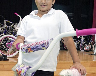 Kelsey Morales, age 10, of Campbell proudly displays her new bike earned with passing all three parts of the 4th Grade OAT.