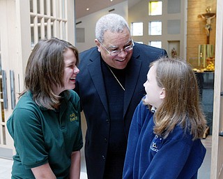 Bishop George Murry shares a lighter moment with Holy Family School 8th graders Mary Kate Stevens, left, and Sarah Summers while visiting the school for a mass celebrating its 50th anniversary Wednesday.