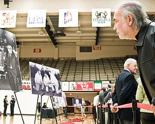 Lewis Ramos of Canfield leans over the barrier to get a closer look at a photo while in line at Dom Rosselli's calling hours. Photos and a memorial for Rosselli were set up in the YSU gym.