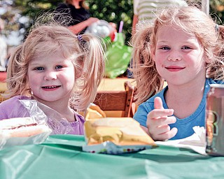 Carolyn, 4, and her sister Evelyn, 6, Engle are enjoying their food at the free Fall festival at Idaho Road Church where their father is the Pastor.