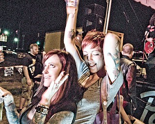 Melanie Verdream, left, and Casey Cox rock out to punk rock band "The Cheats" at the Royal Oaks bar in Youngstown. Several bands played all day for the event, dubbed "Pabstolutely" after its main sponsor, Pabst beer.