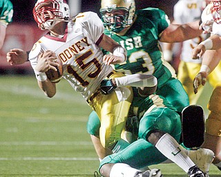 Mooney QB Alex Zordich gets caught behind the line of scrimmage and winces in pain as #15 Ursuline Dominique Coleand #53 Ursuline's Mike Herns bring him down hard in the third quarter