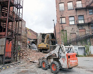 TEARING DOWN: A bulldozer is a sure sign that the 90-day remediation and demolition project of the State Theatre and the Armed Forces Building on West Federal Street has begun.  The two buildings, between the Wells Building and the John R. Davis Building, will eventually become a high-tech site.