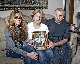 L-R Bianca, Minerva and Virgil sit together with a photo of their son, Virgil Ciprian "Chip" Gilea.