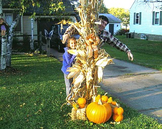 Autumn and Andy Murzda of Hubbard play scarecrow behind pumpkins.