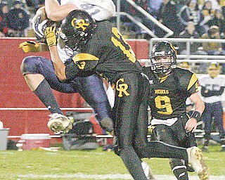 CRESTVIEW - KIRTLAND - (13) Jakob Leon of Crestview puts a big hit on (81) Anthony Ritossa as (9) Adam Britton comes in to help during their game Saturday night in Niles.