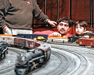 FAMILY AFFAIR: Frank Carbon of Boardman and his son, Gregory, 2, watch a model train round the bend during the YMRA event.