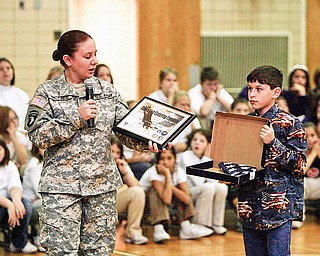 SPECIAL GIFT - Army National Guard Specialist Sandra Nickells with her son Tyler Nickells presented a flag to the school - during the ceremony at Frank Ohl Middle School in Austintown.