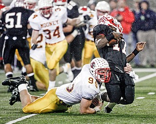 BENDING BUT NOT BREAKING - Mooney's John Simon #95 - catches Big Reds QB #17 Dwight Macon for a big loss during first half action at Fawcett Stadium in Canton