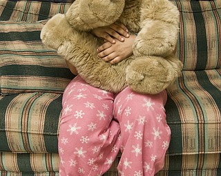 Georgia poses in the game room of a house sponsored by the Ursuline Sisters AIDS Ministry for children infected or affected by HIV/AIDS.  The house offers meals, counseling and academic help to Georgia and 25 other kids who have the disease or live with someone who does.  She has been visiting several times a week basis since age 6, when her mother was diagnosed with HIV, and is comfortable enough to arrive in her pajamas.  
Though the feeling of isolation attached to caring for a family member with HIV solidified for Georgia and her older brother almost a decade ago, she has still only one friend outside of the house who knows her mom is infected.   
Daily worry about her mother dying coupled with the fear of being mocked by other kids has closed her off, she said.
"They don't know what its like. The girls and make fun you for the stupidest things," Georgia said. "I'm used to being quiet at school. When I'm here [at the house], I can express myself."