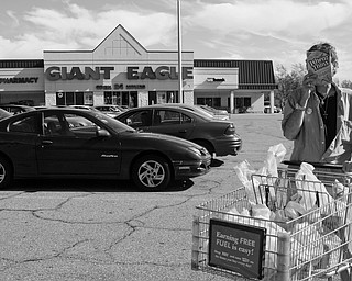 Christian Edward Owens, a gay, white HIV+ male from Warren blocks his face with a box of Wheat Thins on his way out of a Giant Eagle Supermarket. Chris said he has moved all over the country because disclosing his status continually leaves him ostracized wherever he is living.  
"People don't know how big the HIV population is. If you look around the grocery there's someone with HIV. We eat food...we're just like you," he said.