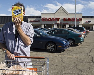 Christian Edward Owens, a gay, white HIV+ male from Warren blocks his face with a box of Wheat Thins on his way out of a Giant Eagle Supermarket. Chris said he has moved all over the country because disclosing his status continually leaves him ostracized wherever he is living.
"People don't know how big the HIV population is. If you look around the grocery there's someone with HIV. We eat food...we're just like you," he said.