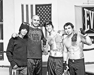 Guitarist Stevie D. of Buckcherry, World Middleweight Champion Kelly Pavlik, Vocalist Josh Todd of Buckcherry and Buckcherry's personal trainer and private security chief Dan Abell pose inside the ring at Southside Boxing Club Saturday