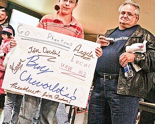 Spencer Steffens (13) of Mecca holds a hand made sign supporting the American auto industry and Phantoms with his grandfather Jim Devlin of Warren at the Phantoms game/community rally at Chevy Centre Friday