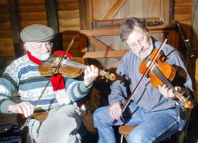 Fiddlers Dennis Kempthorne, left, of Homeworth and Frank Krygowski of Poland were among  the traditional entertainers at the Christmas at the Old Mill in Mill Creek Park Sunday. They were playing traditional Irish and American folk songs. 