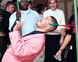 East High School student Trent Jones (17) does the limbo at the annual Winterfest Dance at Mahoning Country Club in Warren, Wednesday