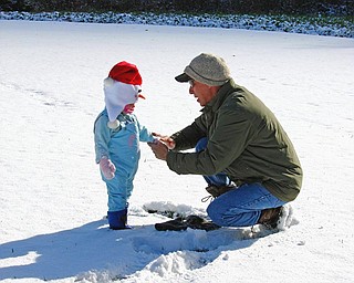 Jeff Hum enjoys the first snow with his niece, Jaylianna Wilt. "Uncle" Jeff was putting her mitten back on after throwing snowballs at "Aunt" Karen. Photo taken by Karen Hum of Canfield.