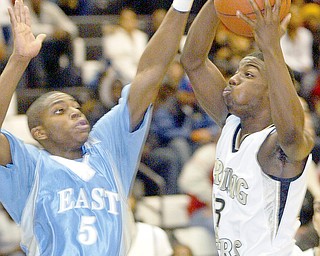 Harding's Fred Williams shoots past Mark Thornton of East during Friday game at Harding.