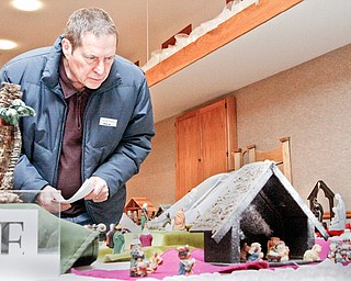 NATIVITY DISPLAY: Jim Beeman of Hiram looks at a group of Nativities at the third annual nativity Display at Villa maria Community Center in Villa Maria, Pa. The display includes 150 Nativities from all over the world from family and community collections.